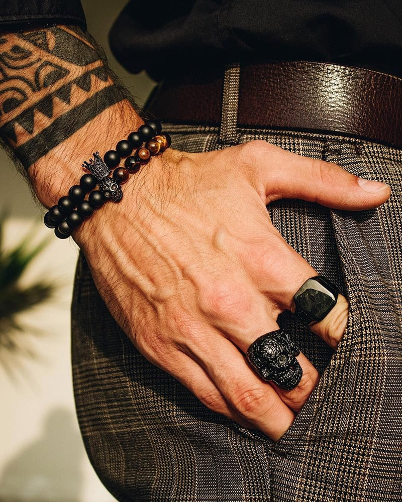 Man Hand with Rings and bracelets in black with skull and crown accessories looking stylish and attractive