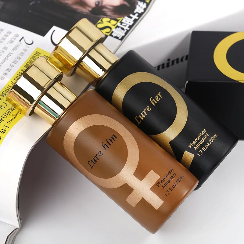 Two pheromone perfume bottles lying down in black and  gold with matching caps and labels, sitting on a magazine surface. The black bottle features a cylindrical shape. Pheromone perfumes can enhance attraction and influence mood, making them a popular choice for romantic occasions. Names are lure him and lure her. Seduction for girls